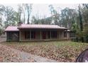 Charming home with a red metal roof, a welcoming front porch, and well-established landscaping at 618 Old Doss Dr, Canton, GA 30115
