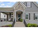 Inviting entrance with stone archway and a well-lit porch, enhancing curb appeal and accessibility at 2003 Haley Walk, Woodstock, GA 30188