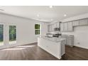 Modern kitchen features gray cabinets, granite countertops, stainless steel appliances, and a center island at 45 Vermillion Trl, Covington, GA 30016