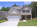 Beautiful two-story home featuring stone accents, black shutters, and a two-car garage, set against a backdrop of green trees at 48 Beaver Pt, Villa Rica, GA 30180
