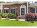 Close-up of brick front featuring flower beds and front door with decorative trim at 2118 Allaire Ne Ln, Atlanta, GA 30345