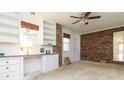 Office area featuring white cabinets, a brick wall, and neutral carpet at 2118 Allaire Ne Ln, Atlanta, GA 30345