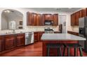 Modern kitchen featuring stainless steel appliances, custom cabinets, an island, and hardwood floors at 7994 Larksview Dr, Fairburn, GA 30213