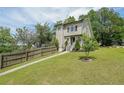 Two-story home with a lush green lawn and landscaping, fenced yard, and mature shade trees at 900 Mill Stone Dr, Marietta, GA 30062