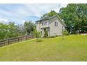 Charming two-story house featuring a manicured lawn, mature trees and landscaping with a fenced yard at 900 Mill Stone Dr, Marietta, GA 30062