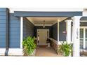 Charming entryway with an elegant white door, complemented by decorative plants and neutral accents at 1056 Riverstone Dr, Social Circle, GA 30025