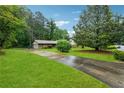 Lovely home featuring a long driveway, lush green lawn, mature trees, and inviting curb appeal at 2255 Chippewa Dr, Riverdale, GA 30296