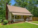 Charming home featuring a cozy front porch with classic railings, chimney, and well-maintained lawn at 500 Nolan Rd, Carrollton, GA 30116