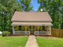 Charming home with a cozy front porch featuring classic railings, flowers and a well-maintained lawn at 500 Nolan Rd, Carrollton, GA 30116
