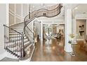 Stunning foyer featuring a spiral staircase, with dark wood floors, and views into the living room at , Buford, GA 30518
