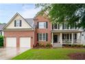 Charming two-story brick home with a well-manicured lawn and attached two-car garage at 138 Knightwood Pt, Acworth, GA 30101