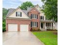 Inviting two-story home with brick and siding, showcasing a well-kept lawn and front porch at 138 Knightwood Pt, Acworth, GA 30101