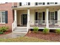 Inviting front porch with classic columns and rocking chairs at 138 Knightwood Pt, Acworth, GA 30101