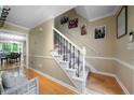 A well-lit staircase with white railings and carpeted steps leads to the upper level of the home at 1769 Milford Creek Sw Cts, Marietta, GA 30008