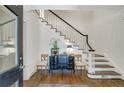 Elegant foyer features staircase, a stylish chest with decor, and hardwood floors at 3382 Habersham Rd, Atlanta, GA 30305