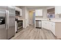 Modern kitchen featuring stainless steel appliances, white cabinets, and durable light gray flooring at 7113 Ambercrest Ct, Austell, GA 30168