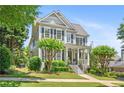 Traditional two-story home with gray siding, black shutters, mature landscaping, and covered front porch at 1974 Mason Mill Rd, Decatur, GA 30033