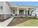 Charming covered front porch with stone accents, decorative plants, and inviting entry door at 6830 Heard Ln, Cumming, GA 30041