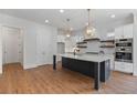 Modern kitchen with stainless steel appliances, a marble island, and stylish pendant lighting at 6830 Heard Ln, Cumming, GA 30041
