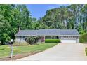 Classic home boasts a well-manicured lawn, an American flag, and an ample driveway at 35 Brooke Holw, Covington, GA 30016