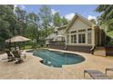 Backyard with a stunning pool and deck surrounded by lush greenery, perfect for outdoor living at 905 Brooksglen Dr, Roswell, GA 30075