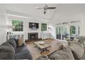 Bright living room featuring hardwood floors, fireplace, large windows, and sliding glass doors at 905 Brooksglen Dr, Roswell, GA 30075