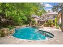 Inviting backyard pool with stone accents surrounded by lush landscaping and mature trees at 973 Peachtree Battle Ave, Atlanta, GA 30327
