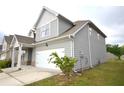 Side view of a gray two-story home with a two-car garage and well-maintained lawn at 2522 Bear Mountain St, Lithonia, GA 30058