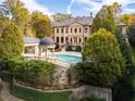 Rear view of a home with a pristine in-ground pool, cabana, and a domed gazebo at 3450 Ridgewood Nw Rd, Atlanta, GA 30327