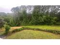 A well-maintained lawn provides a serene backyard setting with lush greenery and a newly-installed fence for privacy at 585 Station View Run, Lawrenceville, GA 30043