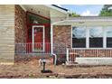 Close up of the brick front porch featuring a red door, white railings, and a bird bath at 2315 Tuxedo Se Dr, Marietta, GA 30067