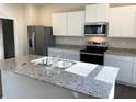Well-lit kitchen showcases granite counters, stainless appliances, and modern white cabinetry at 2701 Montie Ct, Lithia Springs, GA 30122