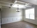 Dining room with elegant coffered ceilings, chandelier, wainscoting, and hardwood floors at 232 Clubhouse Xing, Acworth, GA 30101