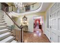 Grand foyer features a winding staircase, chandelier, and parquet floors, leading to the rest of the home at 3456 Paces Nw Pl, Atlanta, GA 30327