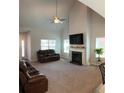 Bright living room with high ceilings, fireplace, fan, plush carpet, and abundant natural light at 457 Panhandle Pl, Hampton, GA 30228