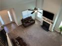 Bright living room with high ceilings, fireplace, fan, plush carpet, and abundant natural light at 457 Panhandle Pl, Hampton, GA 30228