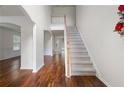 Bright foyer features hardwood floors, a staircase with white railings, and high ceilings at 237 River Pass Ct, Dacula, GA 30019