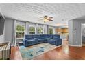 Spacious living room with hardwood floors, large windows, and a cozy blue sectional at 411 Sugar Maple Ct, Canton, GA 30114