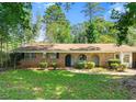 Front exterior showcasing the home's brick facade, arched doorways, and landscaped front yard at 2830 Knollview Dr, Decatur, GA 30034