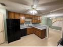 Kitchen featuring wood cabinetry, gray countertops, and modern appliances with a breakfast bar at 608 Fairhaven Blvd, Stockbridge, GA 30281