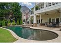 Backyard pool with attached spa, covered patio, and lush landscaping at 1409 Spyglass Hill Dr, Johns Creek, GA 30097