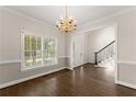 Bright dining room with wood floors, white trim, and a elegant chandelier, offering a view of the staircase at 3040 Larkspur Ct, Cumming, GA 30041