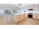 Bright kitchen featuring an island, modern appliances, light wood cabinets, and sliding glass doors to the backyard at 845 Lake Hollow Sw Blvd, Marietta, GA 30064