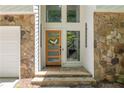 Inviting entryway with stone accents and modern wood door at 110 Fairway Ridge Dr, Johns Creek, GA 30022