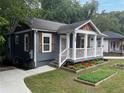 Inviting home with a covered front porch, garden, and a freshly poured concrete driveway at 1100 Welch Sw St, Atlanta, GA 30310