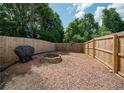Fenced backyard featuring a mulched area and brick fire pit, offering privacy at 1507 Paces Ferry North Se, Smyrna, GA 30080