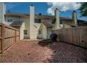 Fenced backyard featuring a mulched area, brick fire pit, and partial view of neighboring homes at 1507 Paces Ferry North Se, Smyrna, GA 30080