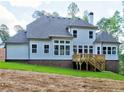 A home's rear exterior featuring a deck, a large backyard and multiple windows providing ample natural light at 3730 Reserve Overlook (Lot 8) Way, Cumming, GA 30041