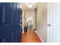 Inviting home foyer featuring wood floors, neutral walls, a modern light fixture and blue front door at 734 Kilkenny Cir, Lithonia, GA 30058
