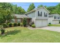 Two story home featuring a well-kept lawn, landscaping, gray siding and a two car garage at 734 Kilkenny Cir, Lithonia, GA 30058